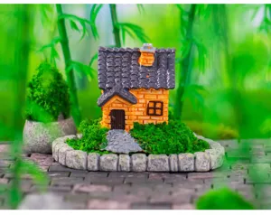 Nahaufnahme der Miniatur Harz Haus Figur mit Moos und Steinmauer fuer Dekoration.