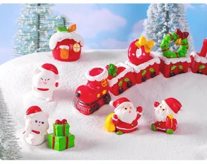 Close-up of Christmas resin miniature figurines with cute Santa and bear for snow scene DIY decor.