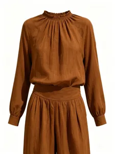 Detail view of the elegant brown long-sleeve top and trousers set, highlighting fabric texture.