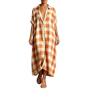 Close-up detail of the orange and white plaid shirt dress hem and buttons for summer.