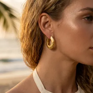 Dettaglio di eleganti orecchini a cerchio in acciaio inossidabile placcati oro 18k