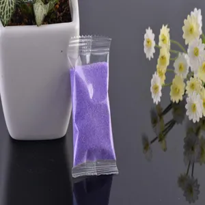 Close-up view of a small transparent packet filled with vibrant purple landscaping sand.