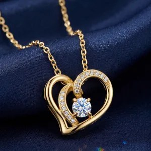 Primer plano de un collar de oro en forma de corazón con diamante moissanite brillante.