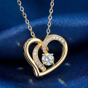 Primer plano detallado de un collar de doble corazón chapado en oro con piedras moissanita