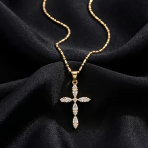 Close-up detail of a gold stainless steel cross necklace with sparkling zircon stones