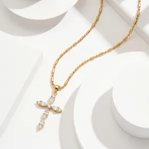 Detail view of a gold stainless steel cross necklace with marquise-cut zircon stones