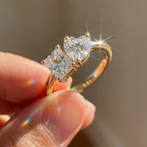 Detailed close-up of 18K gold Toi et Moi ring with heart and princess cut lab diamonds