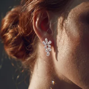 Detailed view of sterling silver lab-grown diamond floral earrings elegantly worn by a model