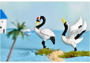 Close-up detail of cute plastic red-crowned crane miniature figurines for succulent decor.
