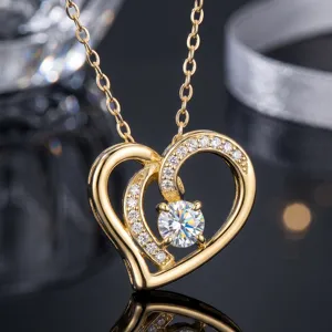 Vista detallada de un collar de doble corazón chapado en oro con una piedra de moissanita