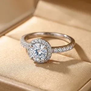 Close-up of a brilliant round Moissanite halo ring set in sterling silver jewelry box