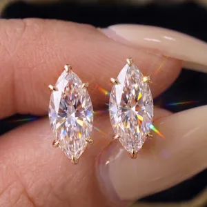 Primer plano de pendientes de moissanita talla marquesa con montura de cuatro garras oro