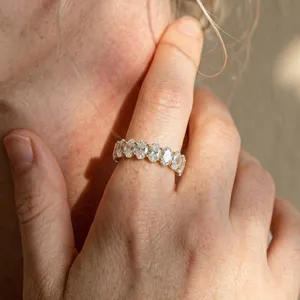 Primo piano di un elegante anello eternity in moissanite argento S925 al dito sotto il sole