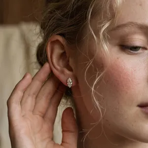 Detalle de primer plano de un pendiente de moissanita talla marquesa en la oreja