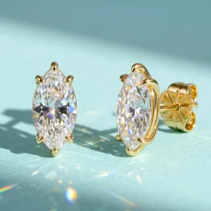 Primer plano de pendientes de moissanita talla marquesa en plata de ley chapada en oro
