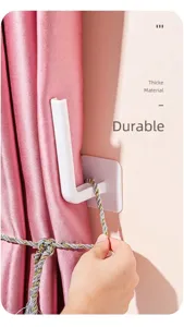 Close-up of white L-shaped adhesive hook used as a wall-mounted curtain tieback