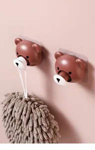 Close-up of cute telescopic bear adhesive hooks holding a brown cleaning mop.