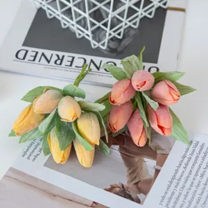 Close-up detail of colorful artificial tulip bouquets with green leaves for DIY crafts and decor.