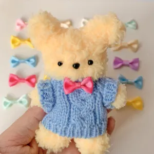 Cute handmade yarn plush puppy toy with blue knitted sweater and mini colorful bow accessories.