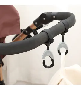 Detalle de ganchos universales para cochecito con correas de velcro sujetando una bolsa de lona