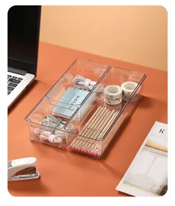 Close-up of a clear plastic desk organizer with two compartments storing stationery.
