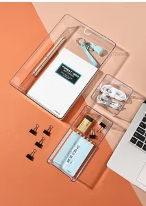 Close-up of transparent acrylic desk organizer trays with stationery items