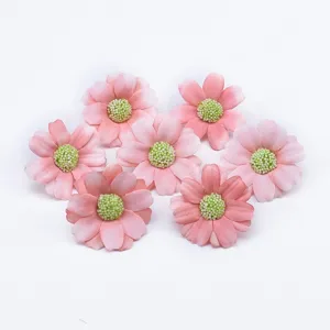 Vista dettagliata di capolini di margherite artificiali rosa per scatole regalo e decoro.
