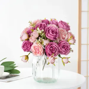 Vista dettagliata di un bouquet di peonie artificiali in vaso di vetro trasparente decoro.