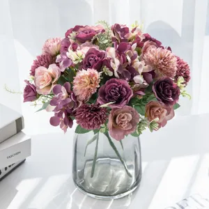 Artificial flower bouquet arrangement in glass vase, elegant home decor table centerpiece.