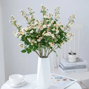 Artificial small rose flowers simulation floral arrangement in white vase for home decor wedding.