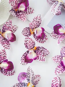 Detailed close-up of artificial film orchid flower flat lay decoration, purple spotted design.