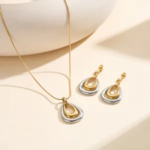 Detalle del elegante conjunto de collar y pendientes geométricos bicolor oro y plata.