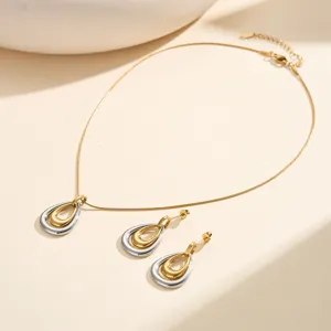 Primer plano del conjunto de collar y pendientes de gota bicolor oro y plata muy elegante
