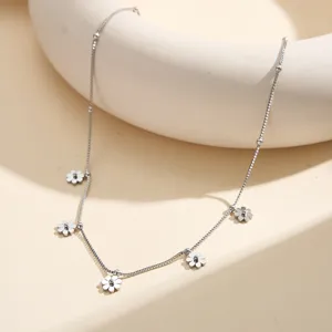 Detailed macro view of a silver stainless steel necklace featuring small flower charms.