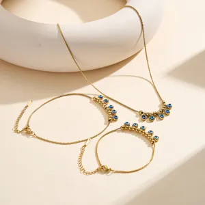 Detailed macro shot of 18K gold plated evil eye jewelry set featuring blue charms