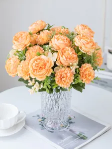 Gedetailleerd uitzicht op kunstmatige oranje pioenen en hortensia's in een glazen vaas.