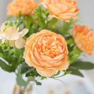 Close-up detail kunstmatige oranje pioenroos bloemenboeket met groene bladeren voor huisdecoratie.