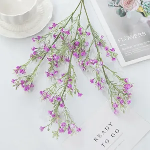 Detailed close-up view of artificial purple baby breath flower branch with green leaves.
