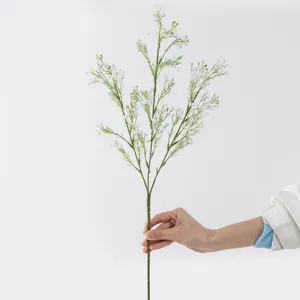 Detail shot of artificial baby breath flower branch, featuring realistic green stem and white blooms.