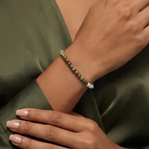 Detailansicht eines Perlenarmbands mit Barockperlen und grünem Naturstein am Handgelenk