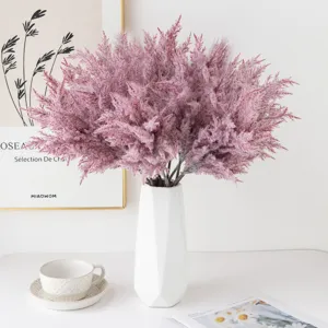 Artificial pampas grass bouquet detail, fluffy pink dried reeds in white ceramic vase, Nordic home decor.