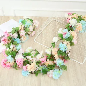 Detailed view of artificial flower vine garland with colorful blooms and green leaves for decor.