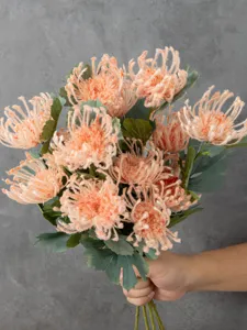 Detail view of artificial orange flocked spider chrysanthemum bouquet for table decor.