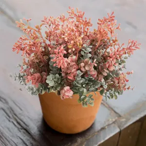 Detailed close-up of artificial eucalyptus potted plant, autumn plastic fake floral decor.