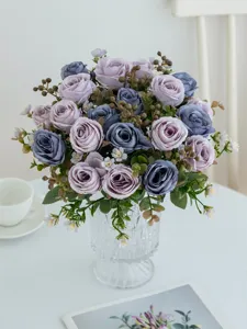 Detailaufnahme eines hochwertigen künstlichen Rosenstrauchs in Glasvase für Dekoration.