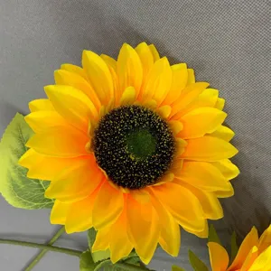 Gros plan détaillé de la tête de tournesol artificiel aux pétales jaunes et tiges vertes.