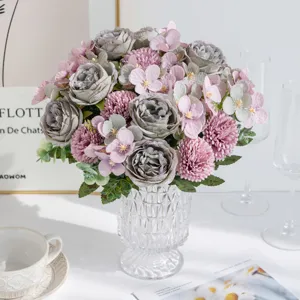 Primo piano dettagliato di un bouquet di fiori artificiali rosa peonia in vaso di vetro.