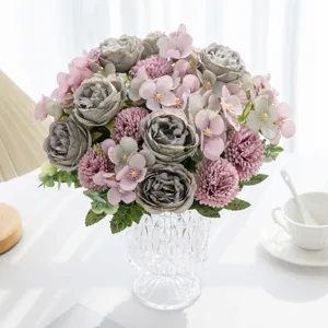 Bouquet di fiori artificiali con rose e peonie in vaso di vetro per decorazione di nozze a casa.