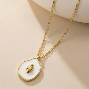 Detailansicht einer weißen Emaille-Halskette mit goldenem Muschel-Motiv Anhänger