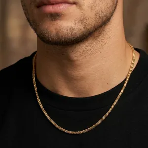 Detailed macro view of a classic gold keel chain necklace on a male model's neck